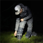 Hunter adjusting the pant cuff over a boot at night